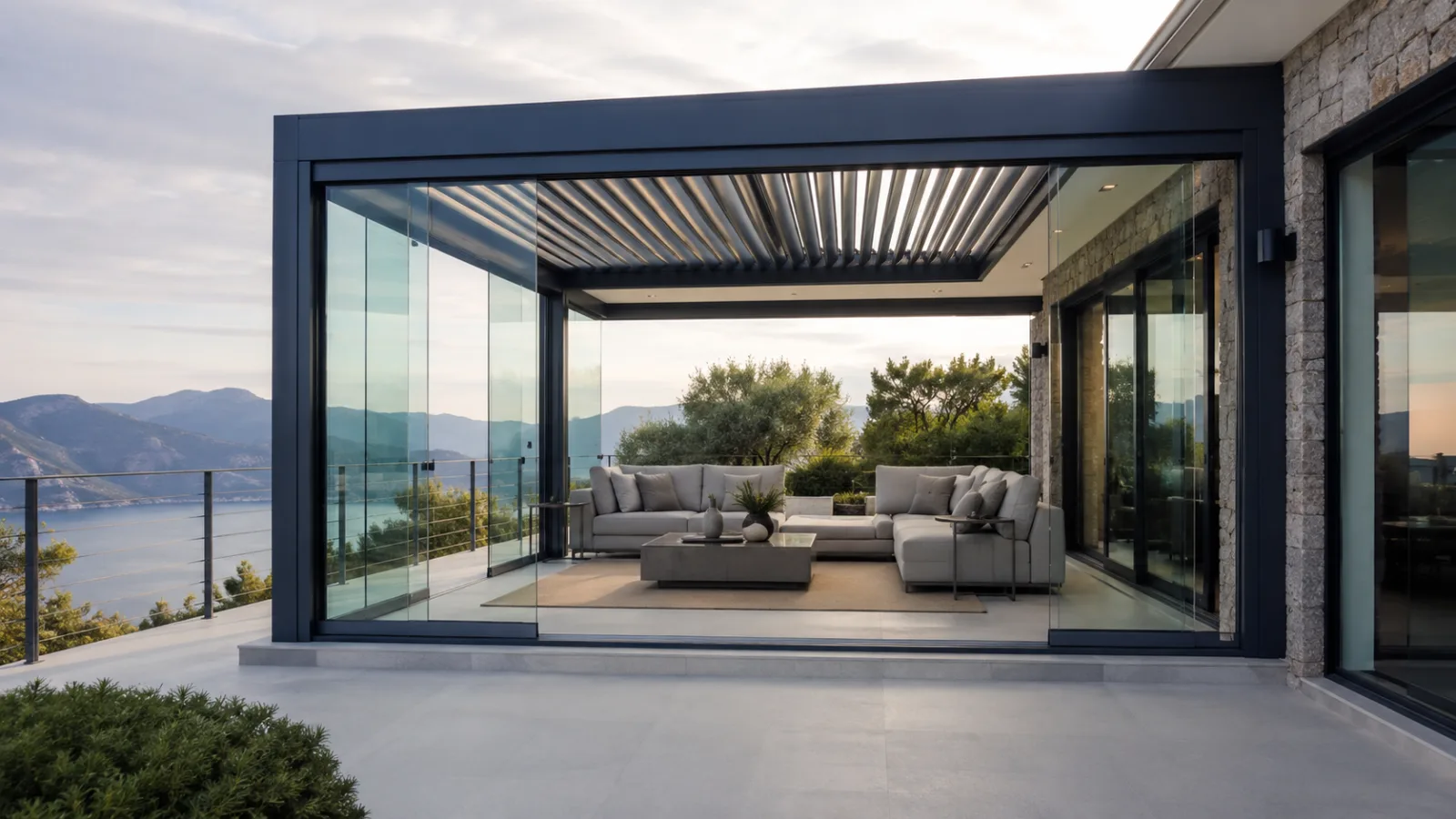 Sürgülü camlarla çevrelenmiş alüminyum pergola altında modern teras oturma alanı
